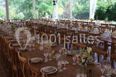 Église en briques rouges avec clocher-mur, entourée d'arbres et située dans un environnement rural.