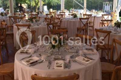 Église en briques rouges avec clocher-mur, entourée d'arbres et située dans un environnement rural.