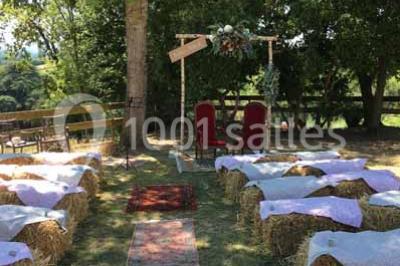 Église en briques rouges avec clocher-mur, entourée d'arbres et située dans un environnement rural.