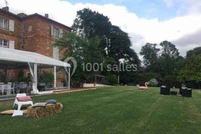 Église en briques rouges avec clocher-mur, entourée d'arbres et située dans un environnement rural.