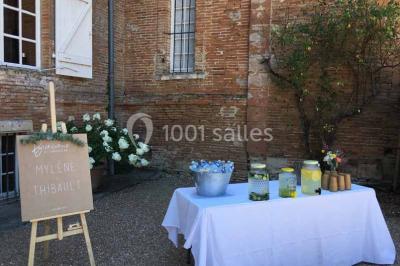 Église en briques rouges avec clocher-mur, entourée d'arbres et située dans un environnement rural.