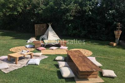 Église en briques rouges avec clocher-mur, entourée d'arbres et située dans un environnement rural.