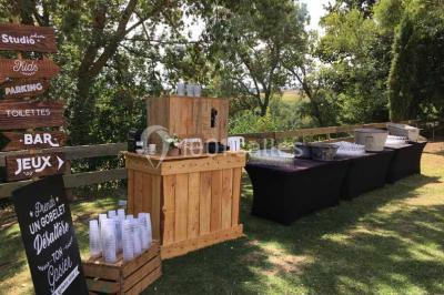 Église en briques rouges avec clocher-mur, entourée d'arbres et située dans un environnement rural.