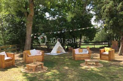 Église en briques rouges avec clocher-mur, entourée d'arbres et située dans un environnement rural.