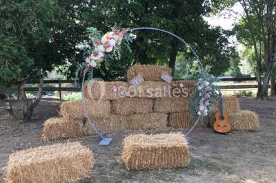 Église en briques rouges avec clocher-mur, entourée d'arbres et située dans un environnement rural.