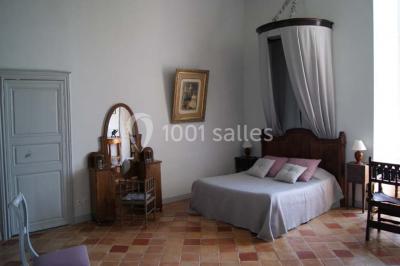 Statue en pierre près d'un escalier en briques, avec des hortensias roses en pots au premier plan.