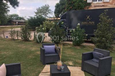 Statue en pierre près d'un escalier en briques, avec des hortensias roses en pots au premier plan.