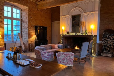 Piscine extérieure entourée de bois et de végétation, avec des transats sous une pergola en bois.