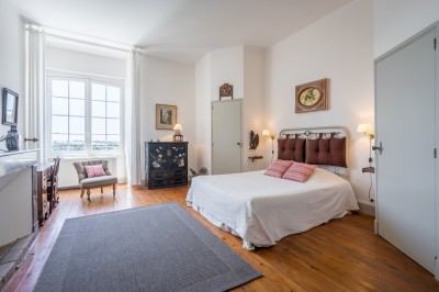 Piscine extérieure entourée de bois et de végétation, avec des transats sous une pergola en bois.