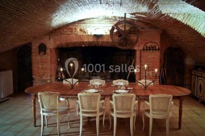 Statue en pierre près d'un escalier en briques, avec des hortensias roses en pots au premier plan.