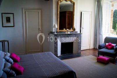 Statue en pierre près d'un escalier en briques, avec des hortensias roses en pots au premier plan.