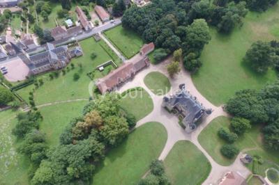 Miniature Location salle Beaulon (Allier) - Château de Beaulon #13 Vue nocturne d'un château illuminé entouré d'arbres, avec une allée sombre au premier plan.
