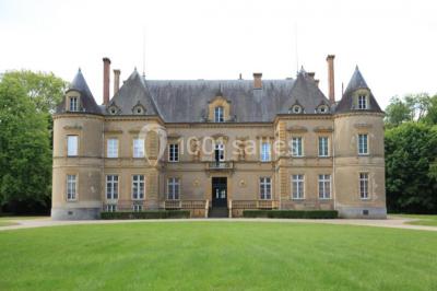 Miniature Location salle Beaulon (Allier) - Château de Beaulon #2 Vue nocturne d'un château illuminé entouré d'arbres, avec une allée sombre au premier plan.