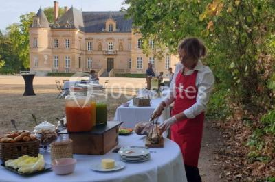Miniature Location salle Beaulon (Allier) - Château de Beaulon #21 Vue nocturne d'un château illuminé entouré d'arbres, avec une allée sombre au premier plan.