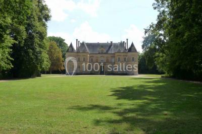 Miniature Location salle Beaulon (Allier) - Château de Beaulon #4 Vue nocturne d'un château illuminé entouré d'arbres, avec une allée sombre au premier plan.