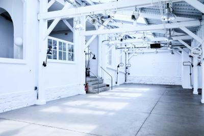 Miniature Location salle Paris 11 (Paris) - Qg Quartier General #2 Salle aménagée pour un événement avec tables recouvertes de nappes rouges, verres, fleurs et équipements de service.