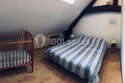 Deux toilettes séparées par une cloison, chacune équipée d'un lavabo, d'un miroir et d'un éclairage au plafond.