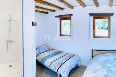 Deux toilettes séparées par une cloison, chacune équipée d'un lavabo, d'un miroir et d'un éclairage au plafond.