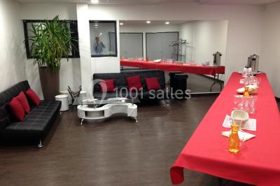 Vue d'un jardin clôturé avec une pelouse, des plantes en pot rouge et un premier plan de feuilles de yucca.