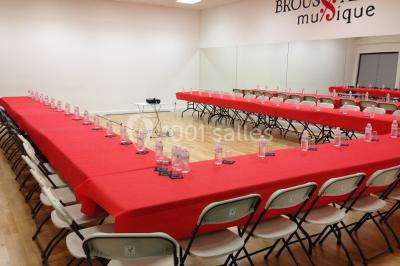 Vue d'un jardin clôturé avec une pelouse, des plantes en pot rouge et un premier plan de feuilles de yucca.