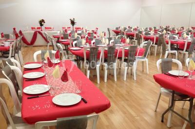 Vue d'un jardin clôturé avec une pelouse, des plantes en pot rouge et un premier plan de feuilles de yucca.