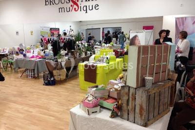 Vue d'un jardin clôturé avec une pelouse, des plantes en pot rouge et un premier plan de feuilles de yucca.