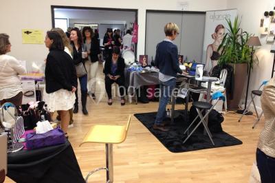 Vue d'un jardin clôturé avec une pelouse, des plantes en pot rouge et un premier plan de feuilles de yucca.