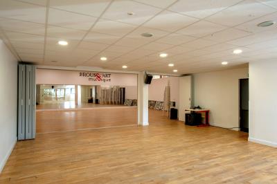 Vue d'un jardin clôturé avec une pelouse, des plantes en pot rouge et un premier plan de feuilles de yucca.