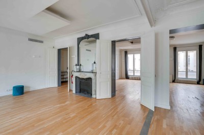 Miniature L'Appart Lafayette – espace modulable pour réception privée Salon lumineux avec parquet en bois clair, cheminée, fauteuils bleus et moulures au plafond.