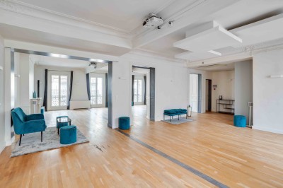 Miniature L'Appart Lafayette – espace modulable pour réception privée Salon lumineux avec parquet en bois clair, cheminée, fauteuils bleus et moulures au plafond.