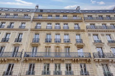 Miniature Les Salons Parisiens – immeuble haussmannien rue La Fayette Paris 9e Salon lumineux avec parquet en bois clair, cheminée, fauteuils bleus et moulures au plafond.