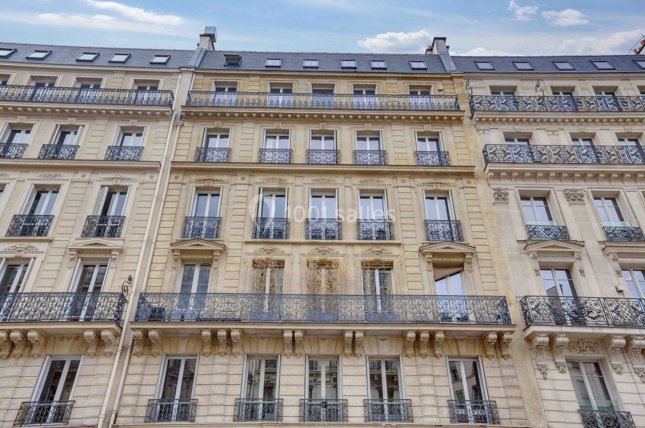 Les Salons Parisiens – immeuble haussmannien rue La Fayette Paris 9e Façade d'un immeuble haussmannien avec balcons en fer forgé et fenêtres alignées sur plusieurs étages.