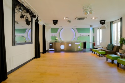 Miniature Les Salons Parisiens – réception privée au cœur de Paris Salon lumineux avec parquet en bois clair, cheminée, fauteuils bleus et moulures au plafond.