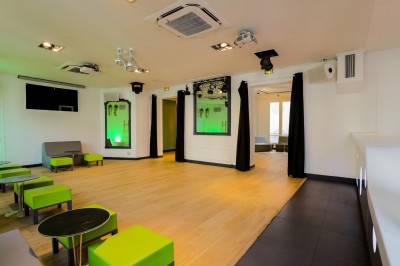 Miniature Salon Lafayette – avec cabine de DJ équipée Salon lumineux avec parquet en bois clair, cheminée, fauteuils bleus et moulures au plafond.