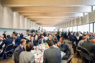 Un groupe de musiciens joue sur scène pendant qu'un public danse dans une salle éclairée et animée.