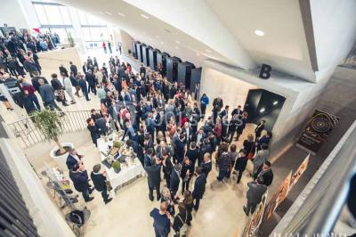 Un groupe de musiciens joue sur scène pendant qu'un public danse dans une salle éclairée et animée.