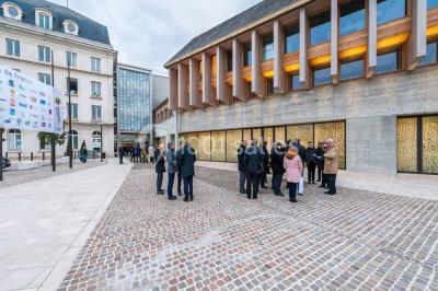 Un groupe de musiciens joue sur scène pendant qu'un public danse dans une salle éclairée et animée.