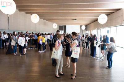 Un groupe de musiciens joue sur scène pendant qu'un public danse dans une salle éclairée et animée.