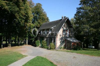 Terrain en cours d'aménagement avec une surface en gravier, entouré de verdure et proche d'un espace de jeux clôturé.