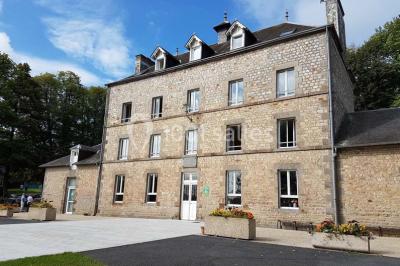 Terrain en cours d'aménagement avec une surface en gravier, entouré de verdure et proche d'un espace de jeux clôturé.