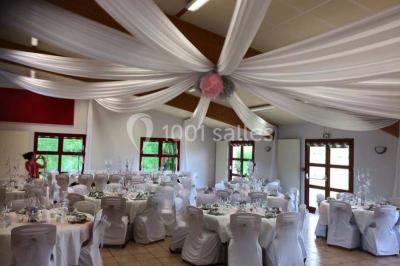 Terrain en cours d'aménagement avec une surface en gravier, entouré de verdure et proche d'un espace de jeux clôturé.