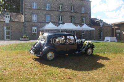 Terrain en cours d'aménagement avec une surface en gravier, entouré de verdure et proche d'un espace de jeux clôturé.