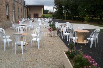 Terrain en cours d'aménagement avec une surface en gravier, entouré de verdure et proche d'un espace de jeux clôturé.