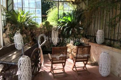 Miniature Location salle Sète (Hérault) - Le Jardin #21 Un vélo vintage avec un panier de fleurs, entouré de pots et arrosoirs fleuris sur un sol en gravier.