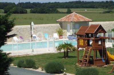 Miniature Location salle Chauvigny (Vienne) - Les Gîtes d’Isel #21 Terrasse avec table, chaises en plastique et parasol, située devant une maison en pierre avec jardin gazonné.