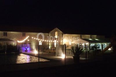 Miniature Location salle Chauvigny (Vienne) - Les Gîtes d’Isel #13 Terrasse avec table, chaises en plastique et parasol, située devant une maison en pierre avec jardin gazonné.