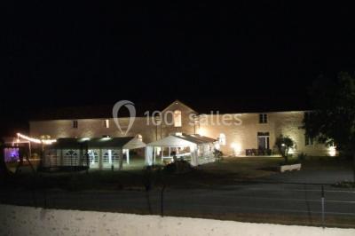 Miniature Location salle Chauvigny (Vienne) - Les Gîtes d’Isel #7 Terrasse avec table, chaises en plastique et parasol, située devant une maison en pierre avec jardin gazonné.