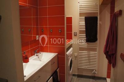 Miniature Location salle Chauvigny (Vienne) - Les Gîtes d’Isel #15 Terrasse avec table, chaises en plastique et parasol, située devant une maison en pierre avec jardin gazonné.