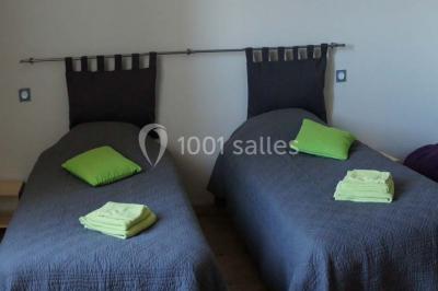 Miniature Location salle Chauvigny (Vienne) - Les Gîtes d’Isel #16 Terrasse avec table, chaises en plastique et parasol, située devant une maison en pierre avec jardin gazonné.