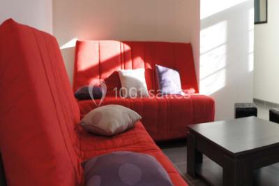 Miniature Location salle Chauvigny (Vienne) - Les Gîtes d’Isel #19 Terrasse avec table, chaises en plastique et parasol, située devant une maison en pierre avec jardin gazonné.